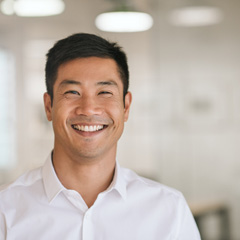 Teenage boy smiling while holding clear aligner